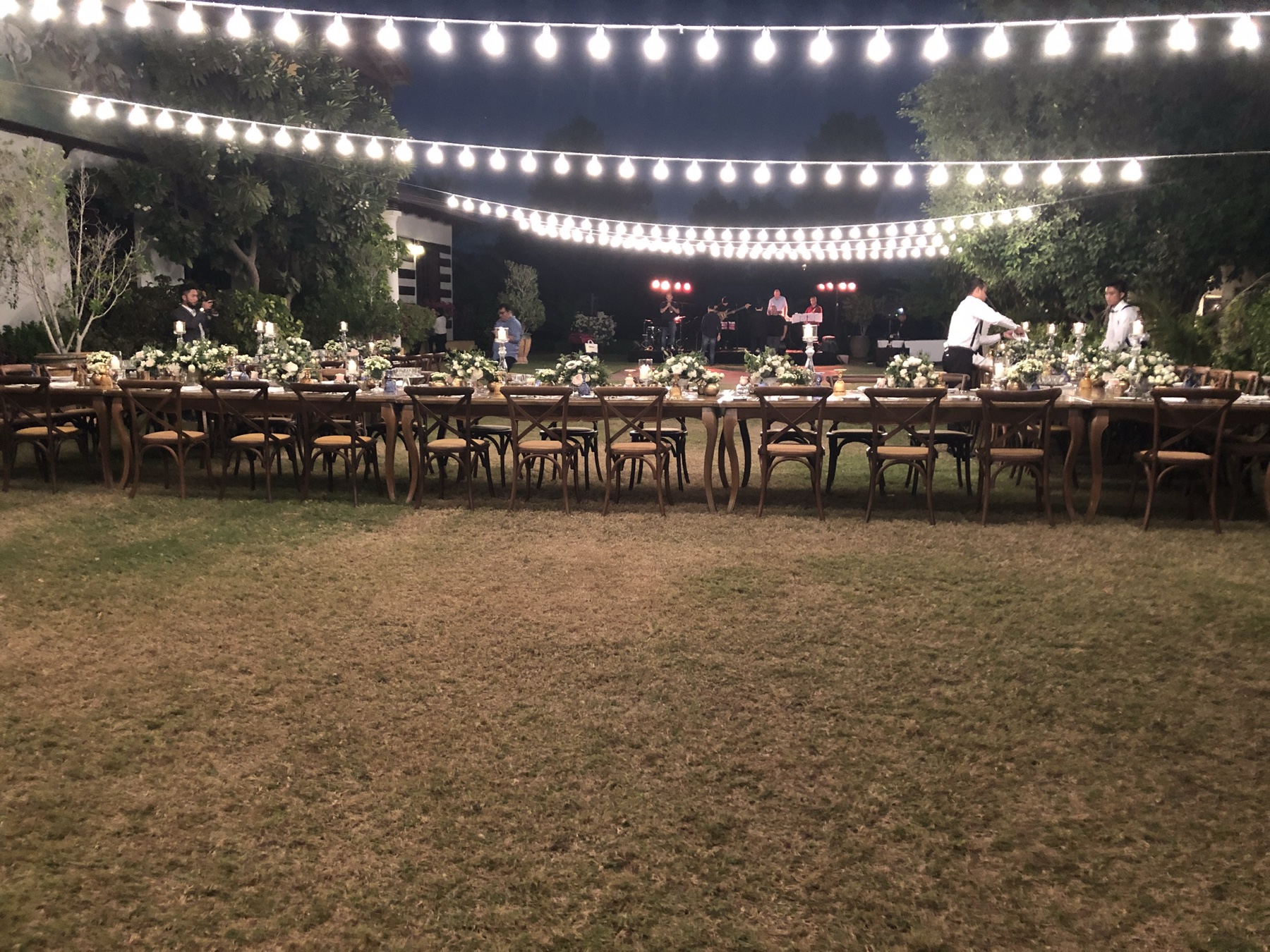 Our wedding dinner setting on the lawn at Meliá Desert Palm, beneath strings of lights